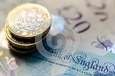 British money. Macro photo of One Pound coins and the British pound banknotes of different denomination Editorial Stock Photo
