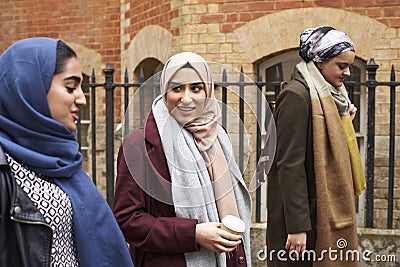 British Muslim Female Friends Walking In Urban Environment Stock Photo