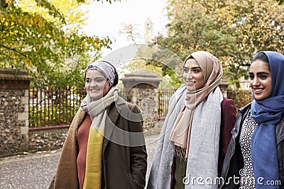 British Muslim Female Friends Walking In Urban Environment Stock Photo