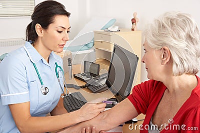 British nurse giving injection to senior woman Stock Photo