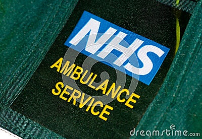 British paramedics`s NHS AMBULANCE SERVICE uniform badge. Editorial Stock Photo