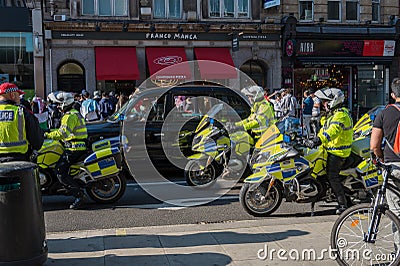 British police motorcyclists and a black London taxi cab at a Freedom for Palestine protest rally Editorial Stock Photo