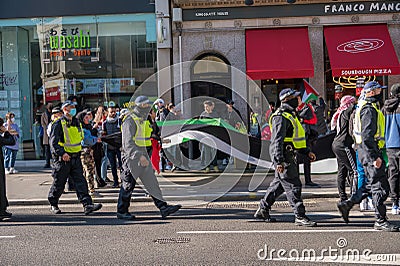 British police officers walk alongside protesters at a Freedom for Palestine protest rally in London Editorial Stock Photo
