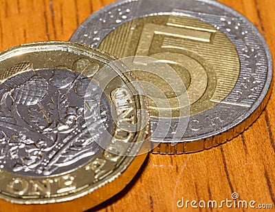 British Pound Coin on top of 5 Polish Zloty A Stock Photo