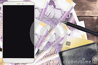 20 British pounds bills and smartphone with purse and credit card. E-payments or e-commerce concept. Online shopping and business Editorial Stock Photo