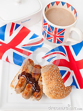 British sausage sandwich with, brown sauce, cup of tea and flag Stock Photo