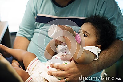 Brizilian father feeding toddler daughter Stock Photo