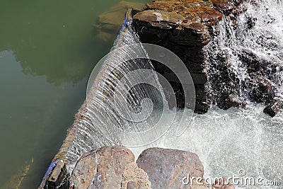 A broad dam spans across the river Stock Photo