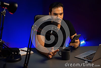 Broadcaster talking to listener checking message from phone. Surmise. Stock Photo