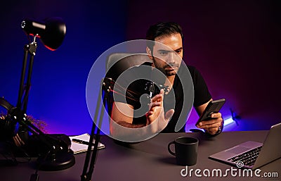 Broadcaster talking to listener checking message from phone. Surmise. Stock Photo