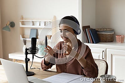 Indian woman in headphones speak using professional microphone by laptop Stock Photo