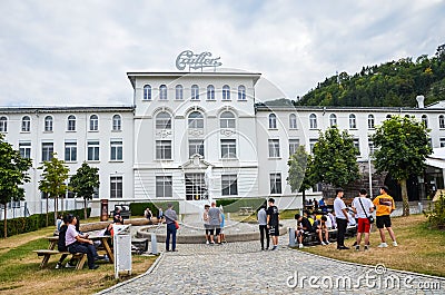 Broc, Switzerland - July 27, 2019: Visitors waiting in front of the building of the famous Cailler chocolate factory. People in Editorial Stock Photo