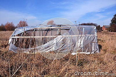 Broken abandoned plastic greenhouse hothouse Stock Photo