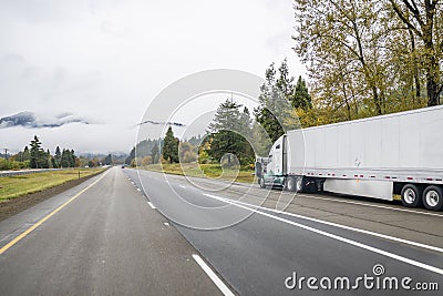 Broken big rig semi truck with open hood and semi trailer standing out of service on road shoulder waiting for towing truck or Stock Photo