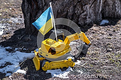 Broken children`s toy and Ukrainian flag. Stock Photo