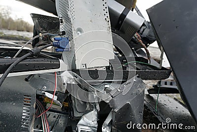 Broken computer parts, monitors and printers in front of nature landscape with a river background. Discarded electronic Stock Photo