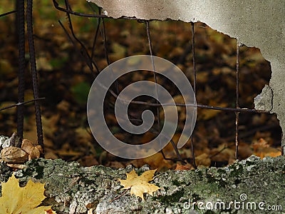 A broken concrete fence. A hole from a shell in a concrete fence. Stock Photo