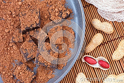 Broken dark chocolate with organic cacao powder and peanuts Stock Photo