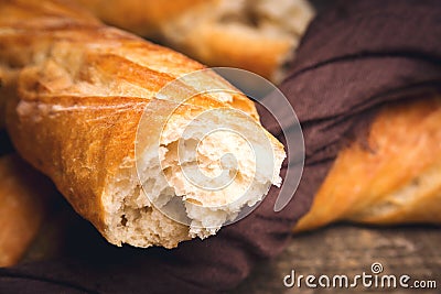 Broken fresh baguette, close up. Fresh baked bread loaf on wooden background. Tasty broken bread Stock Photo