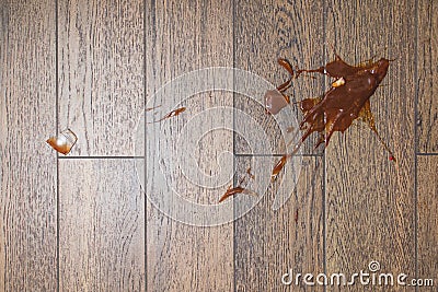 Broken glass bottle of bright red tomato sauce on white tile floor with roll of white paper towel, scene from above Stock Photo