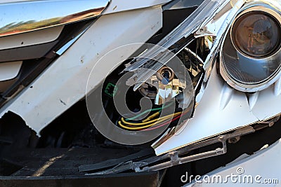 Broken headlights, hood, and bumper of a car after a collision. Stock Photo