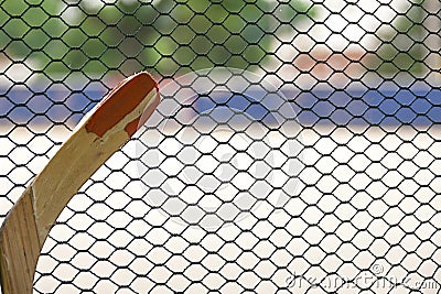 Broken hockey stick leaning up against the outside of the rinks mesh Stock Photo