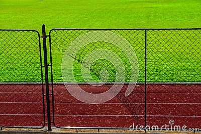 Broken iron wire fence and athletic race track Stock Photo