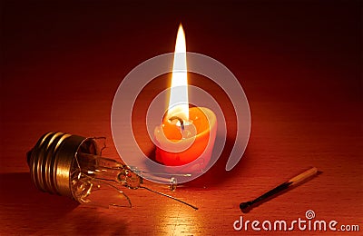 Broken light bulb and candle Stock Photo