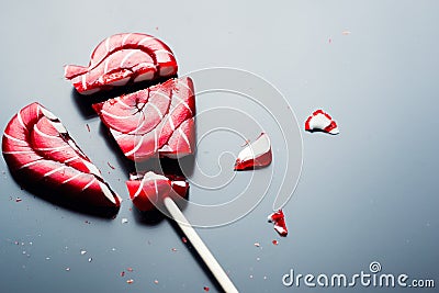 Broken lollipop in shape of heart on a dark background with copy space Stock Photo