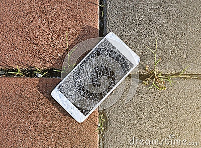 Broken mobile phone drop on stone paved sidewalk out Stock Photo