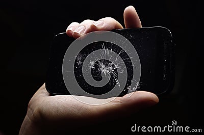 broken phone in hand on dark background, crash phone, fractured, smartphone repair Stock Photo