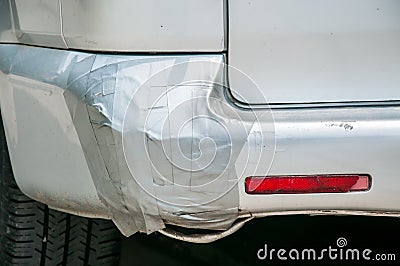 Broken plastic rear end bumper on the silver van glued with duct tape Stock Photo