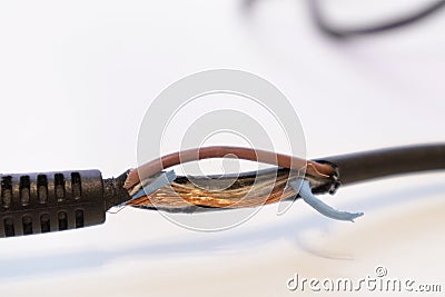 Broken power cord for home electrical appliances, electric tools. Damaged cable insulation. Close-up, soft focus Stock Photo