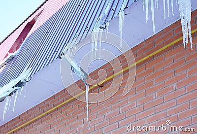 Broken Rain Gutters. Ice dam. Closeup on new broken rain gutter system without roof protection Snow guard on house construction. Stock Photo