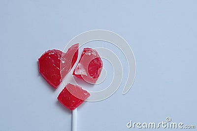 A broken red heart lollipop symbolizing a broken heart Stock Photo