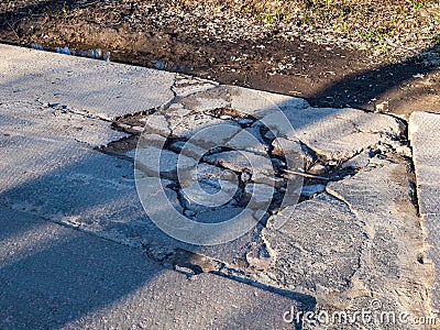 broken road with holes and protruding stones close-up, need for repair of the roadbed, bad road, abandoned Stock Photo