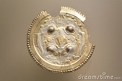 Broken rounded indigenous ancient golden pectoral with a lizard Editorial Stock Photo