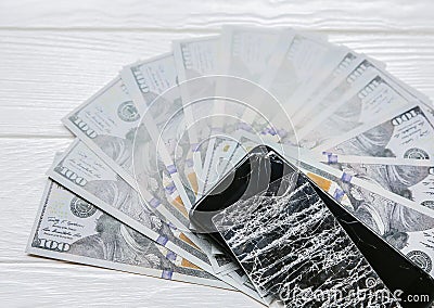 Broken screen protector tempered glass. Money lying near the phone. Dollar notes Stock Photo