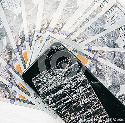 Broken screen protector tempered glass. Money lying near the phone. Dollar notes Stock Photo