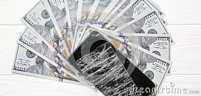 Broken screen protector tempered glass. Money lying near the phone. Dollar notes Stock Photo