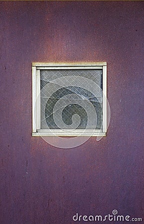 Broken Square Window in a Purple Metal Door Stock Photo