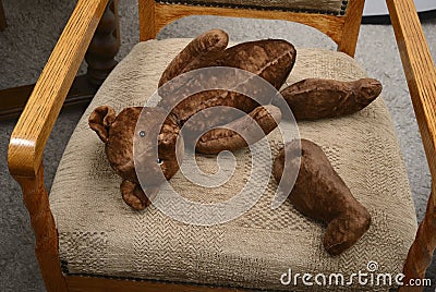 broken teddy bear toy with severed paws on an old armchair Stock Photo