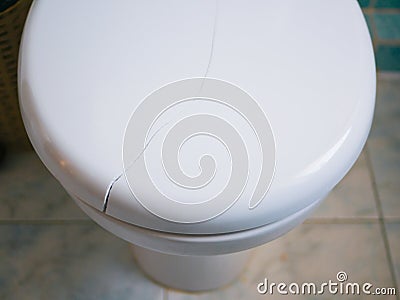 Broken toilet lid. Crack on the toilet lid. Close-up Stock Photo