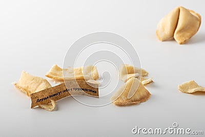 Broken traditional chinese paper tape fortune cookie. You can see the prediction in Russian. Stock Photo