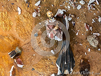 Broken vandalized plaster catholic plaster statues in the ground Editorial Stock Photo