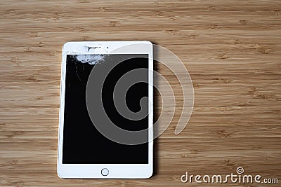 Broken white Ipad in wood background Stock Photo