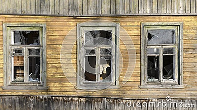 Broken windows in an old wooden ruined house, barrack, ruins Stock Photo