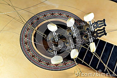 A broken wooden old classic guitar with damaged strings chords, shattered musical instrument, unattached damaged guitar with cut Stock Photo
