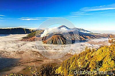 Bromo volcano crater erupt release smoke with sunrise sky background and morning fog landscape at Indonesia Bromo national park Stock Photo