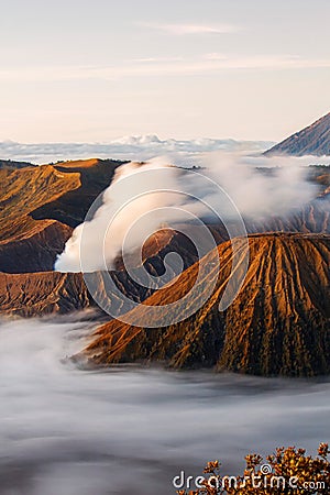 Bromo volcano crater erupt release smoke with twilight sunrise sky background and morning fog landscape at Indonesia Bromo Stock Photo